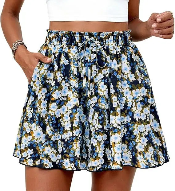 Shorts mit floralem Muster und hoher Taille im A-Linien-Schnitt mit elastischem Bund und Kordelzug, mit blauen, weißen und gelben Blumen auf dunkelblauem Hintergrund.