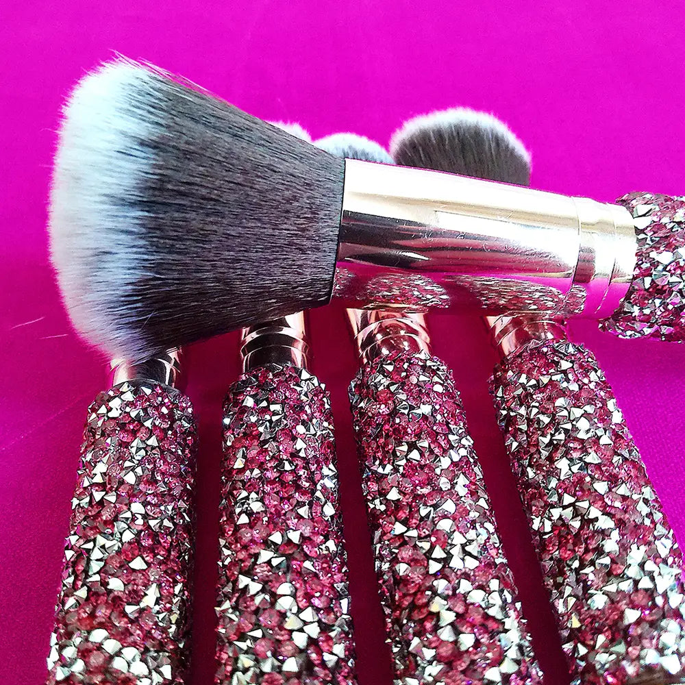 A rhinestone makeup brush set with 10 pieces featuring pink and silver rhinestone-adorned handles, metallic ferrules, and soft bristles in varying shades.