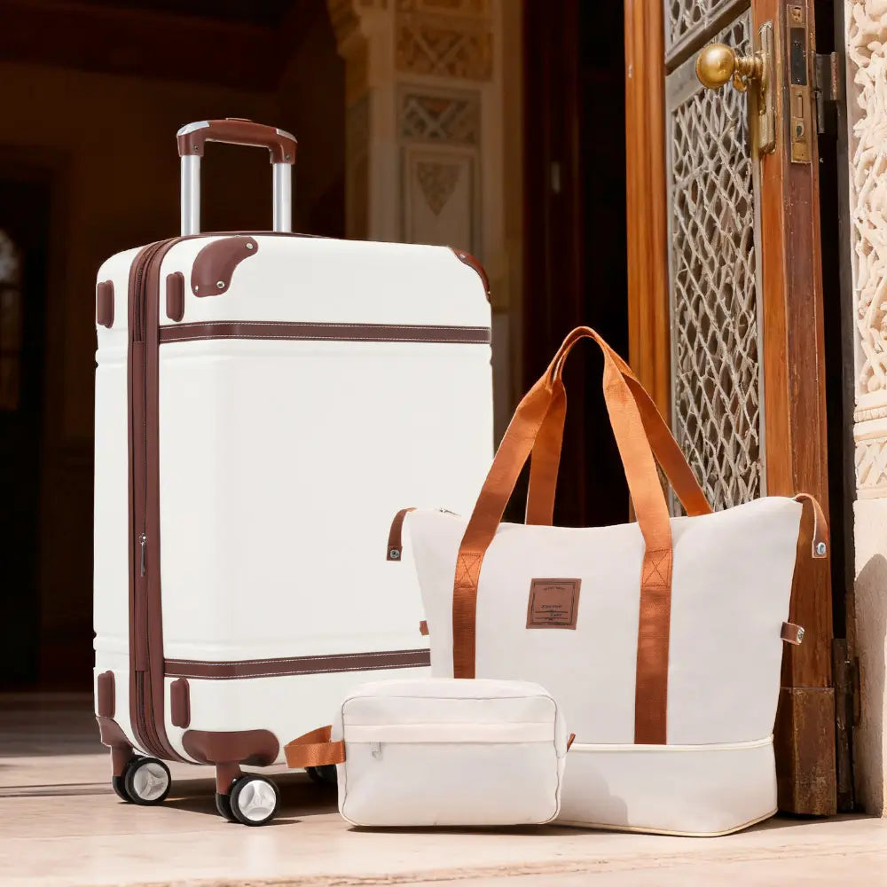 White vintage 24 inch hardshell luggage set with brown leather accents and retractable handle featuring a TSA lock.