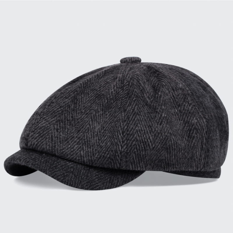 Dark gray herringbone-patterned wool flat cap with a structured six-panel design and short brim in an octagonal beret style.