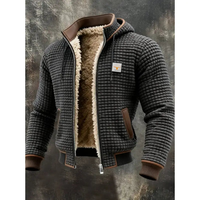 Veste à capuche zippée doublée de polaire pour homme en tissu matelassé gris foncé, passepoils en cuir marron et doublure en shearling beige duveteux.