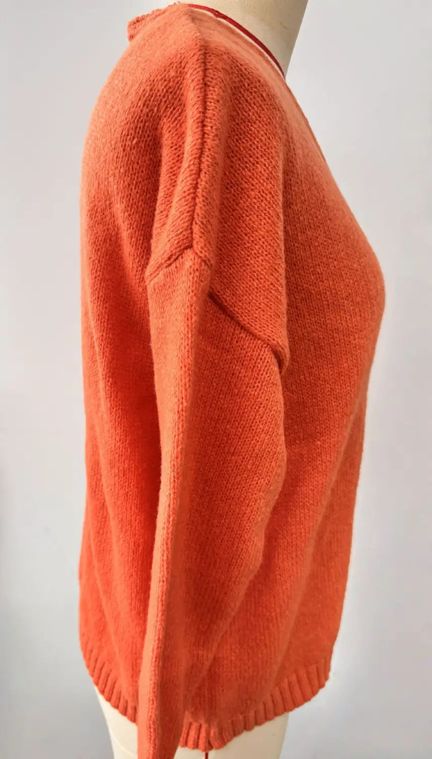 Gemütlicher Strickpullover mit V-Ausschnitt, überschnittener Schulterpartie in Rostorange, mit entspannter Passform und gerippten Bündchen.