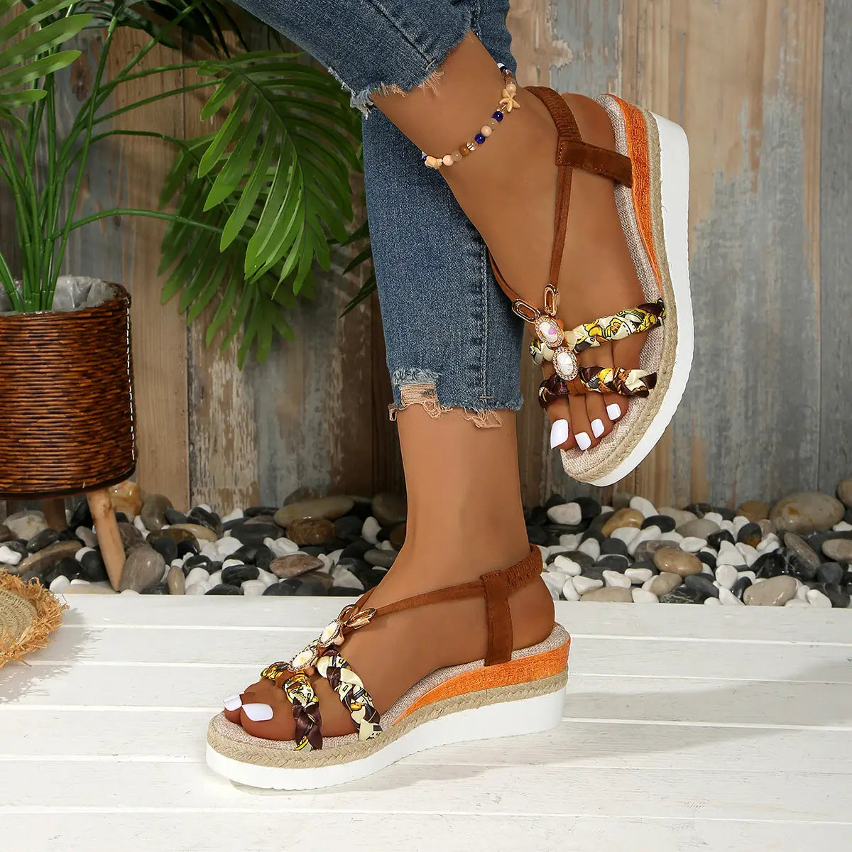 Sandalias tipo cuña marrones para mujer con bailarinas tipo espadrille tejidas, con herrajes decorativos en tono dorado y acentos de tela con patrón.