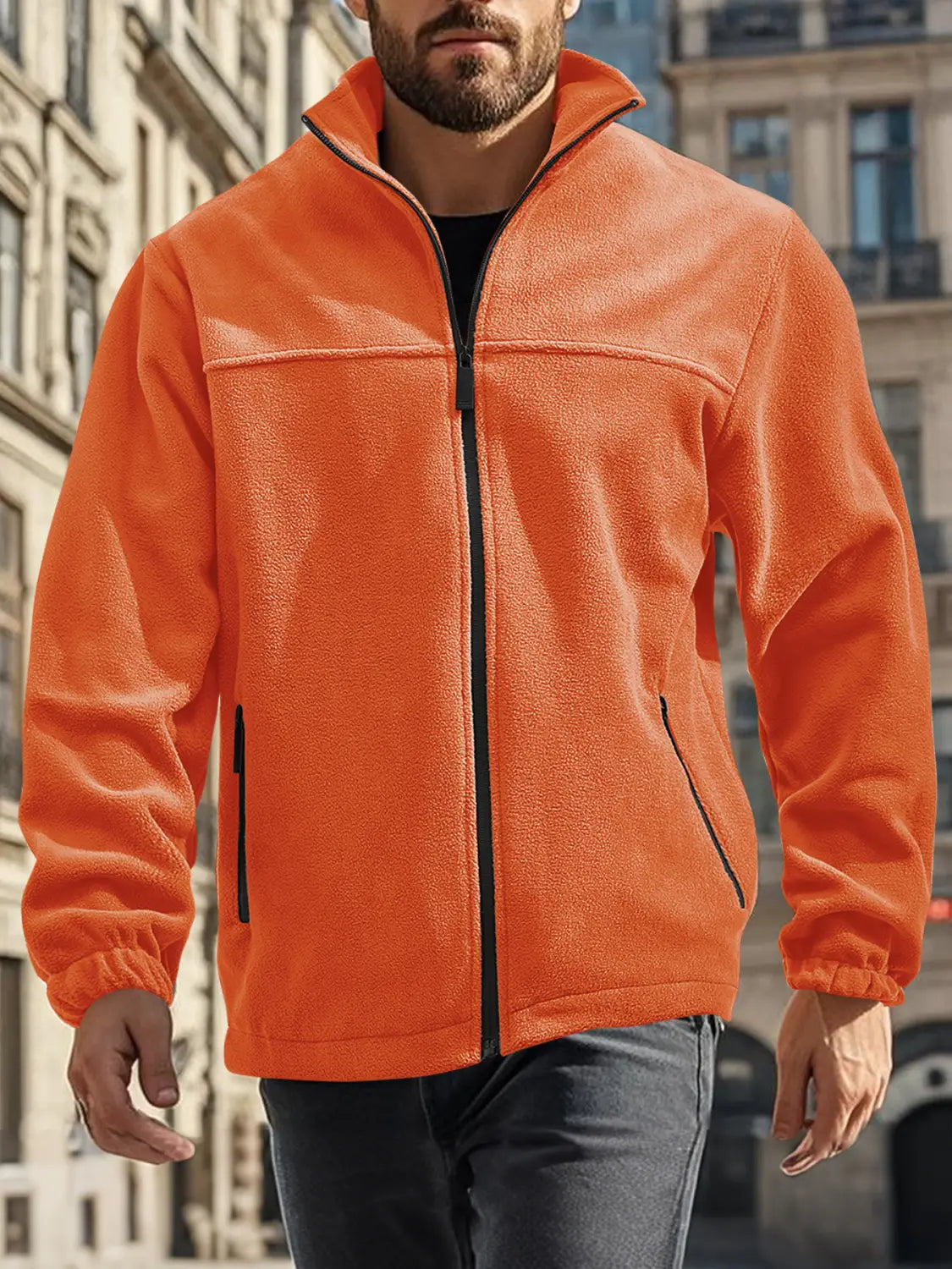 Chaqueta polar para hombre de cierre completo con cuello alto en color naranja brillante, con cremallera negra y bolsillos laterales, confeccionada con material de forro polar suave.