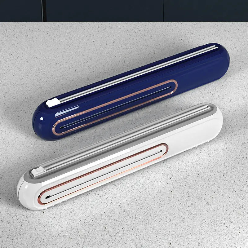 Two sleek modern magnetic cling film cutter and plastic wrap dispensers in deep navy blue and white with glossy finishes and rose gold accent trim.