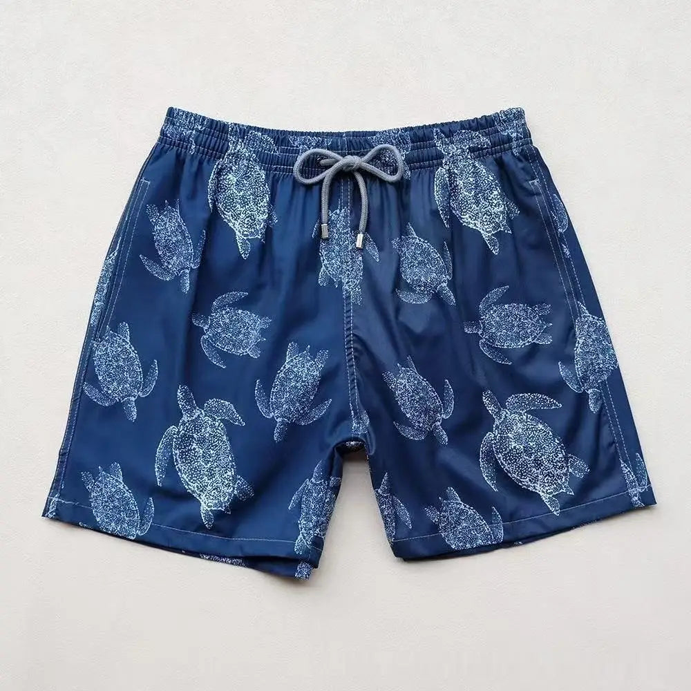 blue turtle quick drying beach pants swim trunks with white sea turtle pattern and gray drawstring waistband.