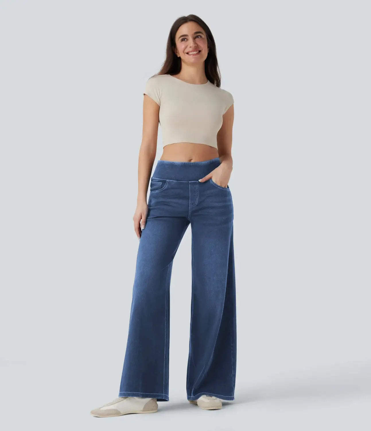 A pair of wide-leg blue denim jeans with a high waist and subtle fading made from stretchy fabric.