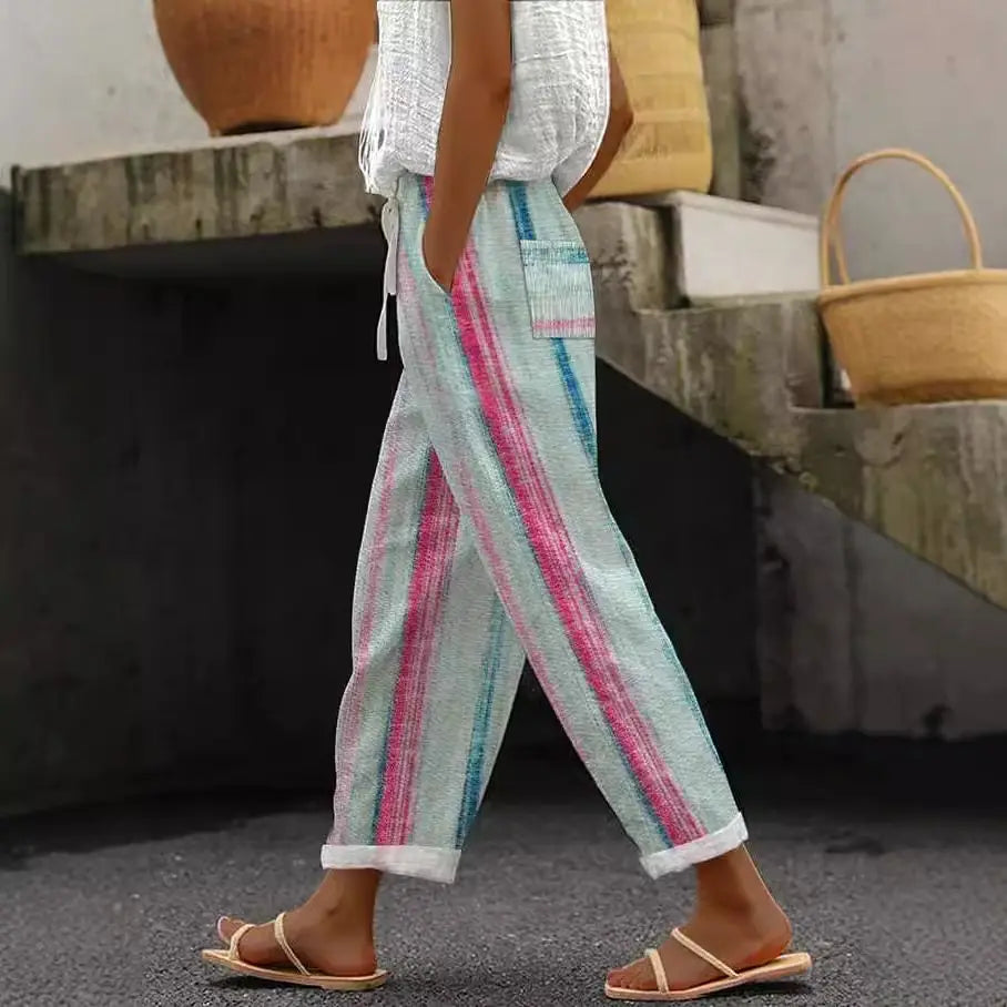 Casual patterned drawstring pocket pants made of light-colored cotton with pink and teal vertical stripes and rolled cuffs.