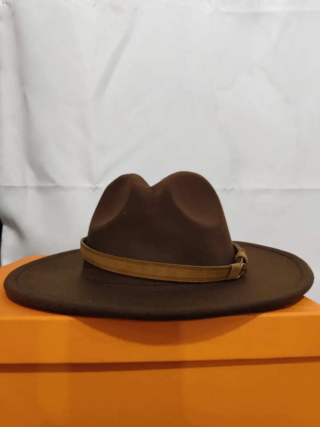 Brown wool fedora hat with tan leather belt and buckle detail.