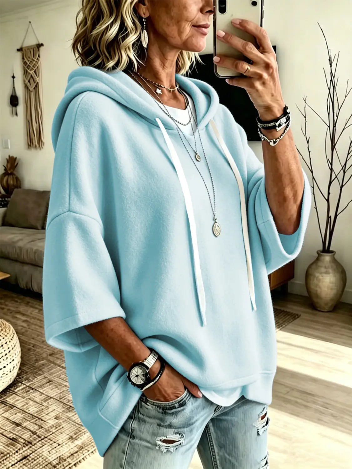 Light blue oversized fleece hooded top with three-quarter sleeves white drawstrings and a relaxed loose fit.