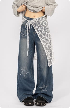Jean bleu en denim à jambes larges, broderie argentée en forme d’étoiles et panneau de dentelle blanche noué à la taille, dans le style du jean noir à jambes larges en patchwork de dentelle en forme d’étoiles.