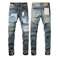 Men’s distressed slim fit denim jeans with patchwork repairs and a faded blue wash.