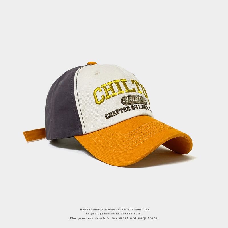 Chapeau de soleil en casquette de baseball rétro à empiècements contrastés, avec arrière bleu marine, panneau avant blanc brodé avec lettrage « Chilton » doré et noir « Chapter 84 Lane », visière orange et sangle ajustable.