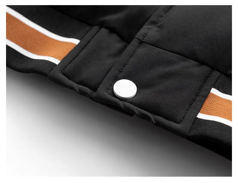 Chaqueta acolchada tipo puffer con capucha para hombre y estampado de letras en color negro, con ribete a rayas naranja y blanco, confeccionado con material aislante para uso en clima frío.