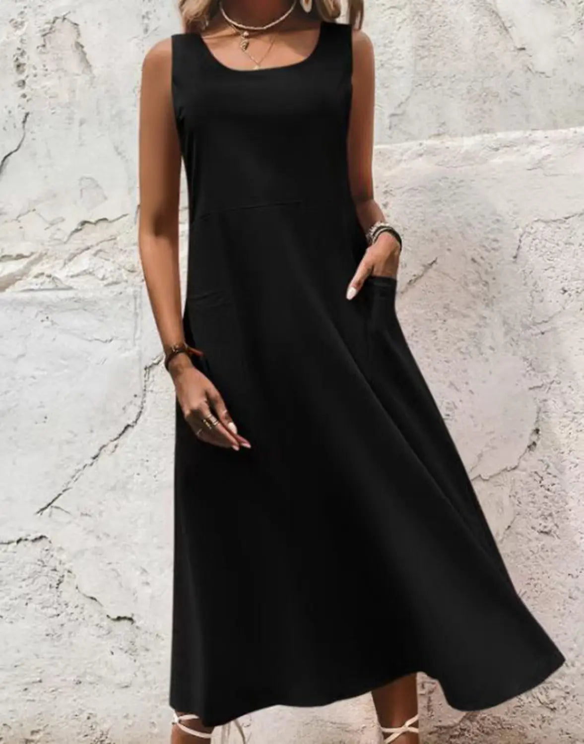 Robe longue maxi sans manches en lin noir, en coupe trapèze en A, avec encolure carrée et poches latérales.