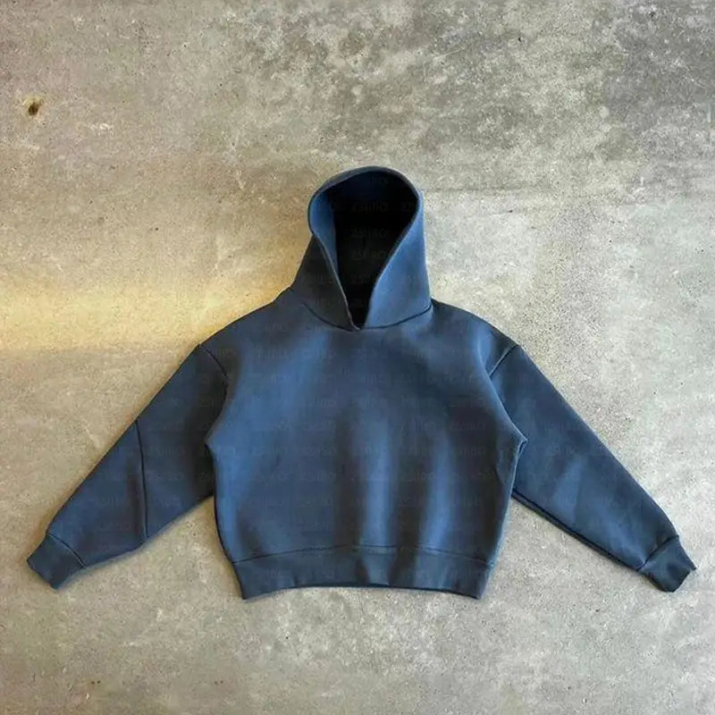 Sweat à capuche court bleu foncé à l’allure souple et décontractée, avec des poignets côtelés, figurant dans un ensemble oversize unisexe streetwear comprenant un sweat à capuche et un pantalon de survêtement.