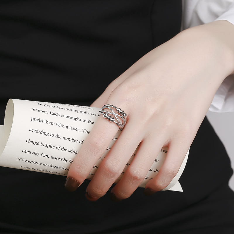 Interwoven silver anxiety relief adjustable ring with a delicate silver-toned intertwined band design and small spherical accents.