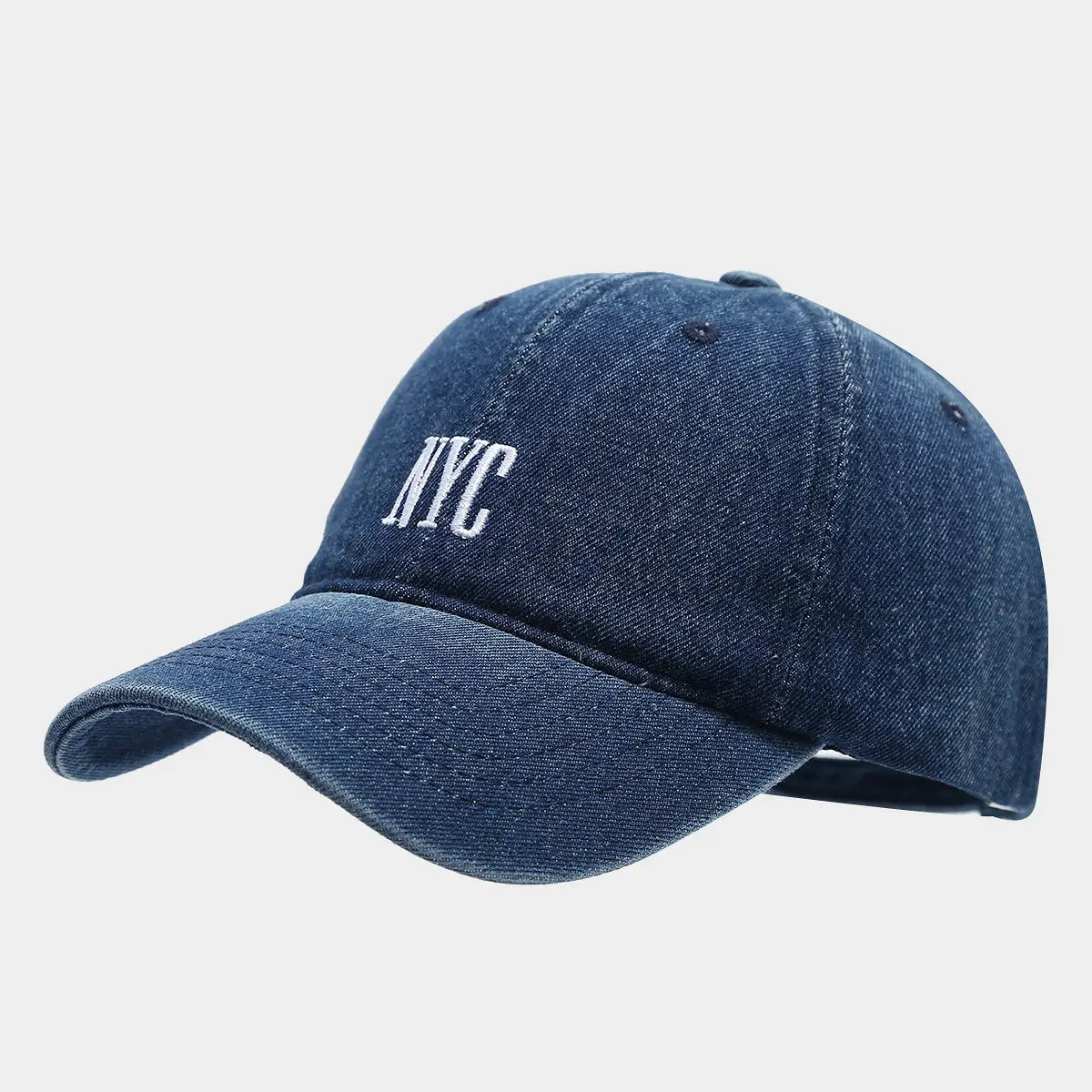 Denim blue baseball cap with white embroidered nyc lettering showcasing retro letter embroidery design.