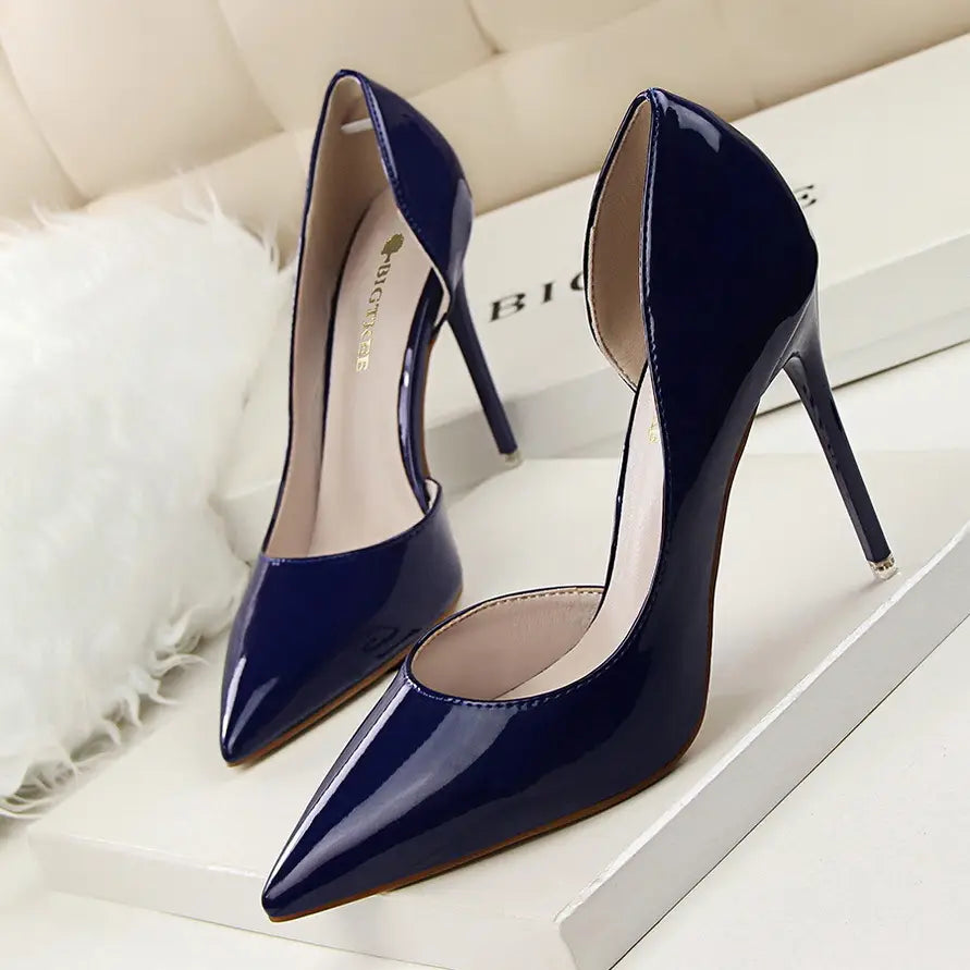 Navy blue patent leather high-heeled pumps with a pointed toe and thin stiletto heel.