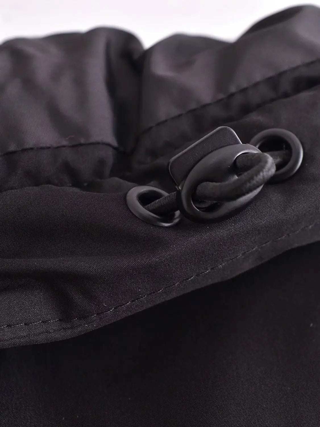 black quilted hooded puffer coat featuring a black nylon drawstring toggle with a matte finish and reinforced stitching