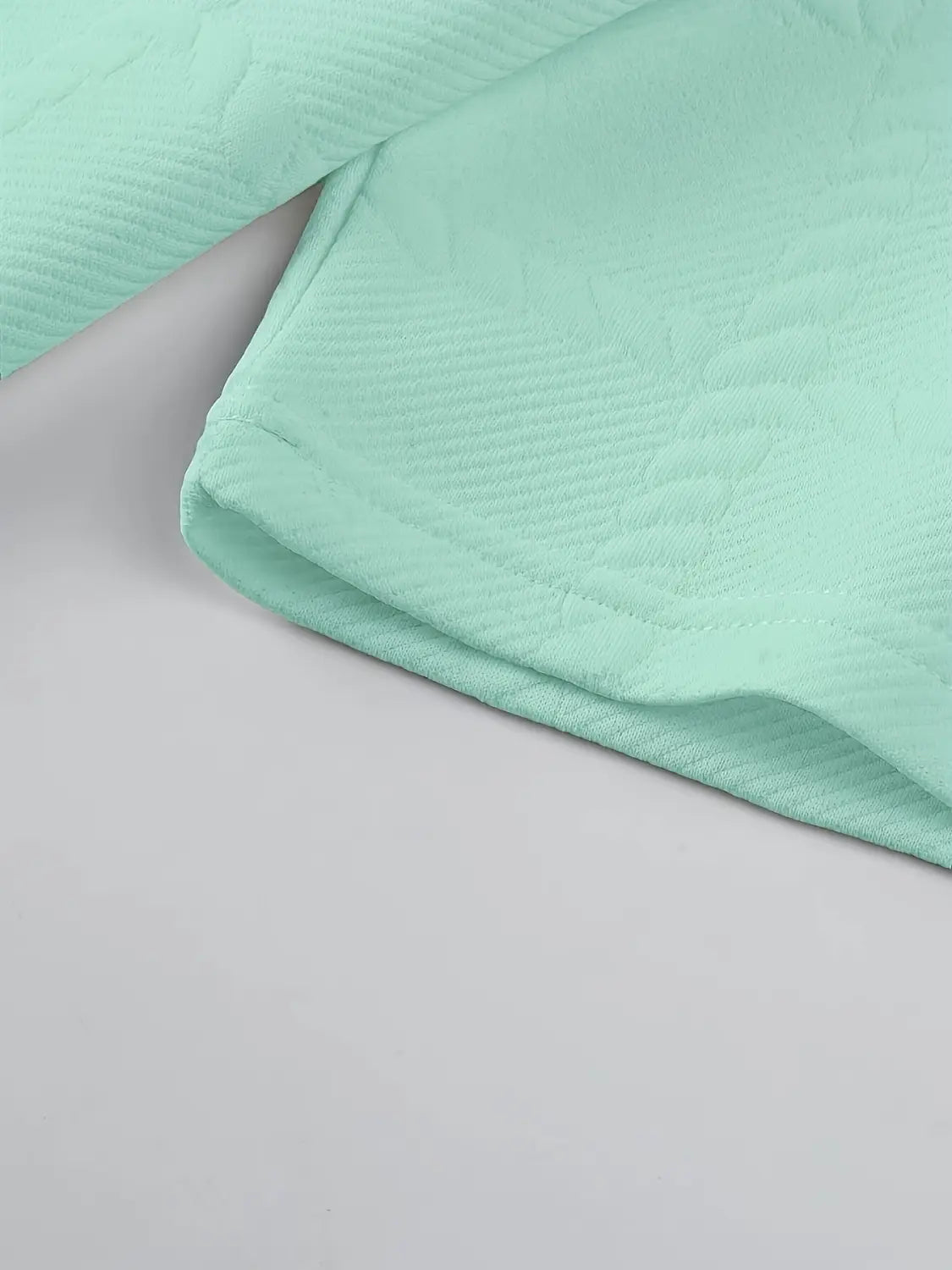 Camisa tipo polo de manga larga verde menta con textura suave, confeccionada en tejido acolchado, con una textura acanalada sutil y bordes cosidos con esmero.