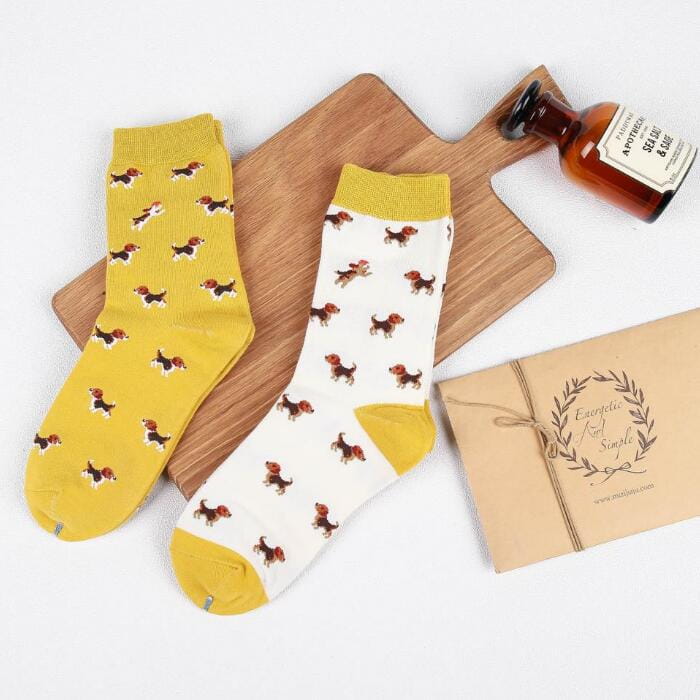 A pair of cotton crew socks featuring playful beagle designs on a vibrant yellow and white base from the cute dog cartoon collection.
