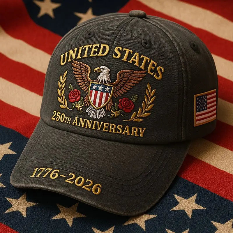 Dark gray baseball cap with embroidered United States 250th anniversary emblem featuring an eagle shield roses and laurel wreath in gold thread and a small American flag patch on the side for a snapback fit.