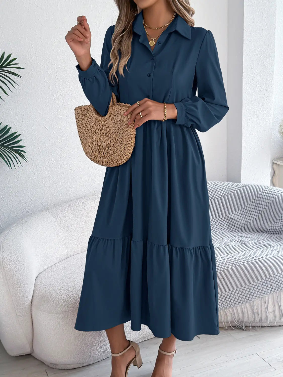 Navy blue long-sleeved tiered midi dress with a collar and button front made of lightweight fabric for women.