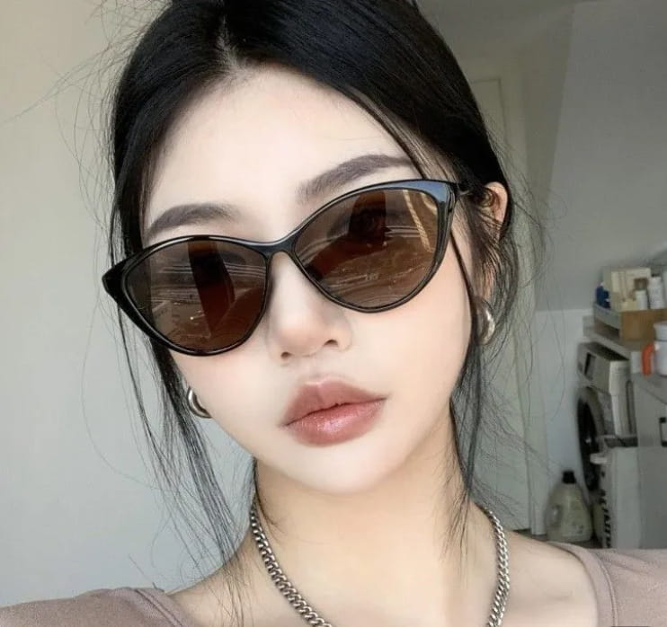 Lunettes de soleil rétro œil-de-chat UV380 légères pour la mode, avec des verres brun foncé et un cadre noir élégant.