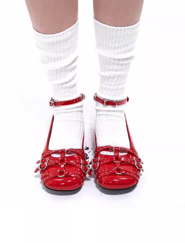 zapatos tipo salón retro de charol rojo con plataforma y correas de hebilla con tachuelas de tono plateado.