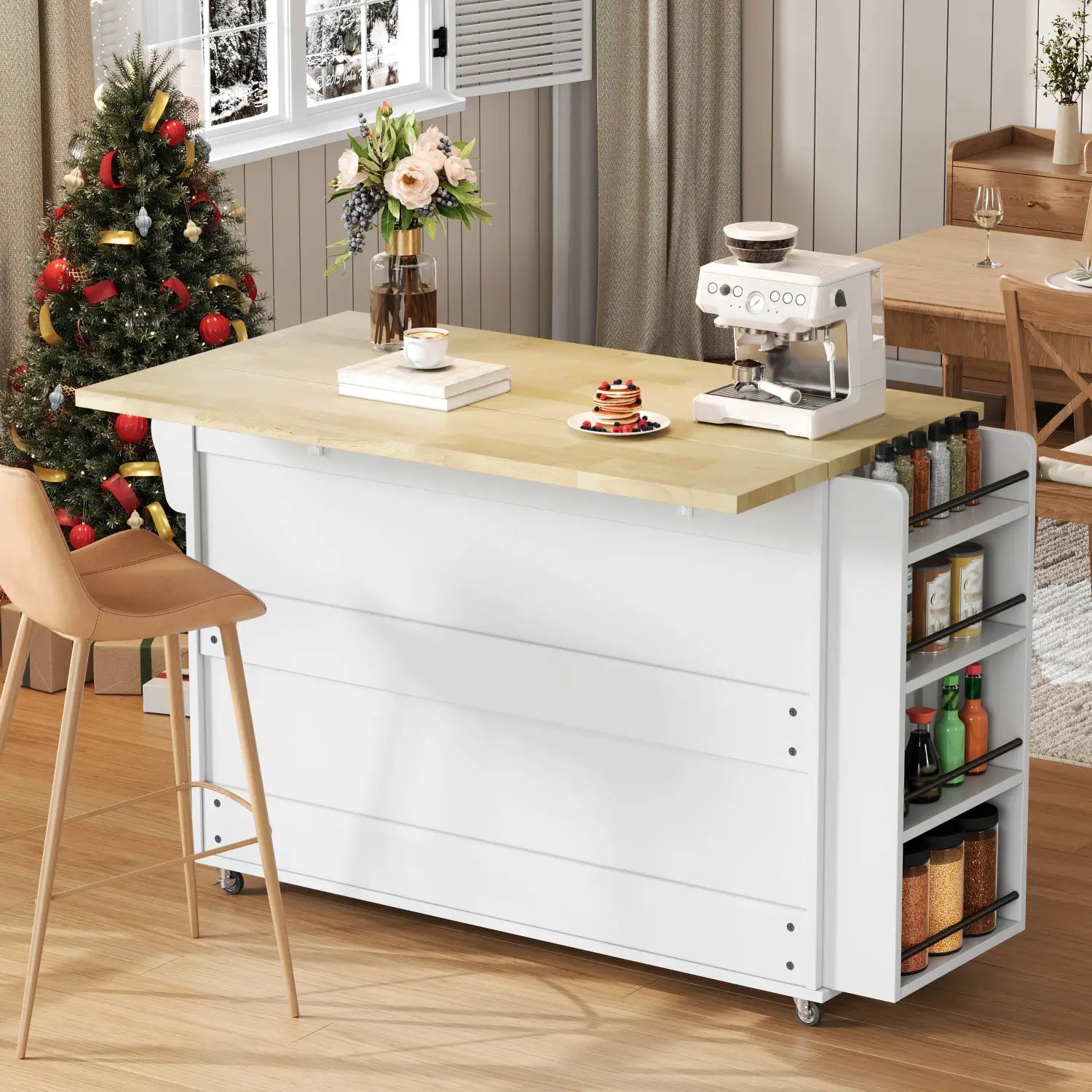 White kitchen cart with light wood countertop and side shelves holding spice jars featuring a foldable worktop and wheels as a mobile kitchen island.