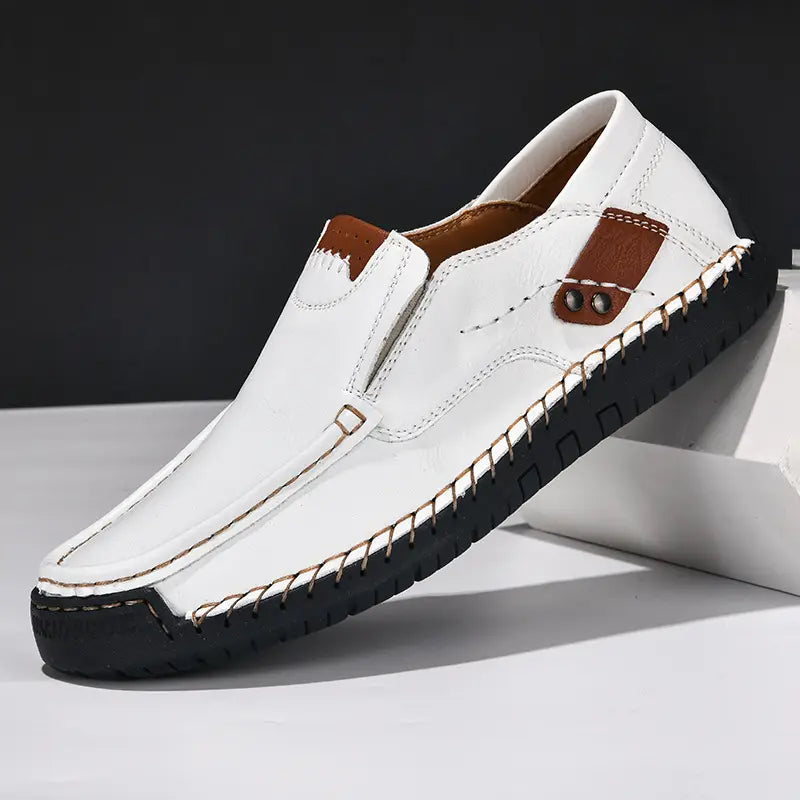 Mocassin décontracté pour homme en cuir blanc, pour sorties en plein air, avec des accents marron et des détails de coutures visibles.