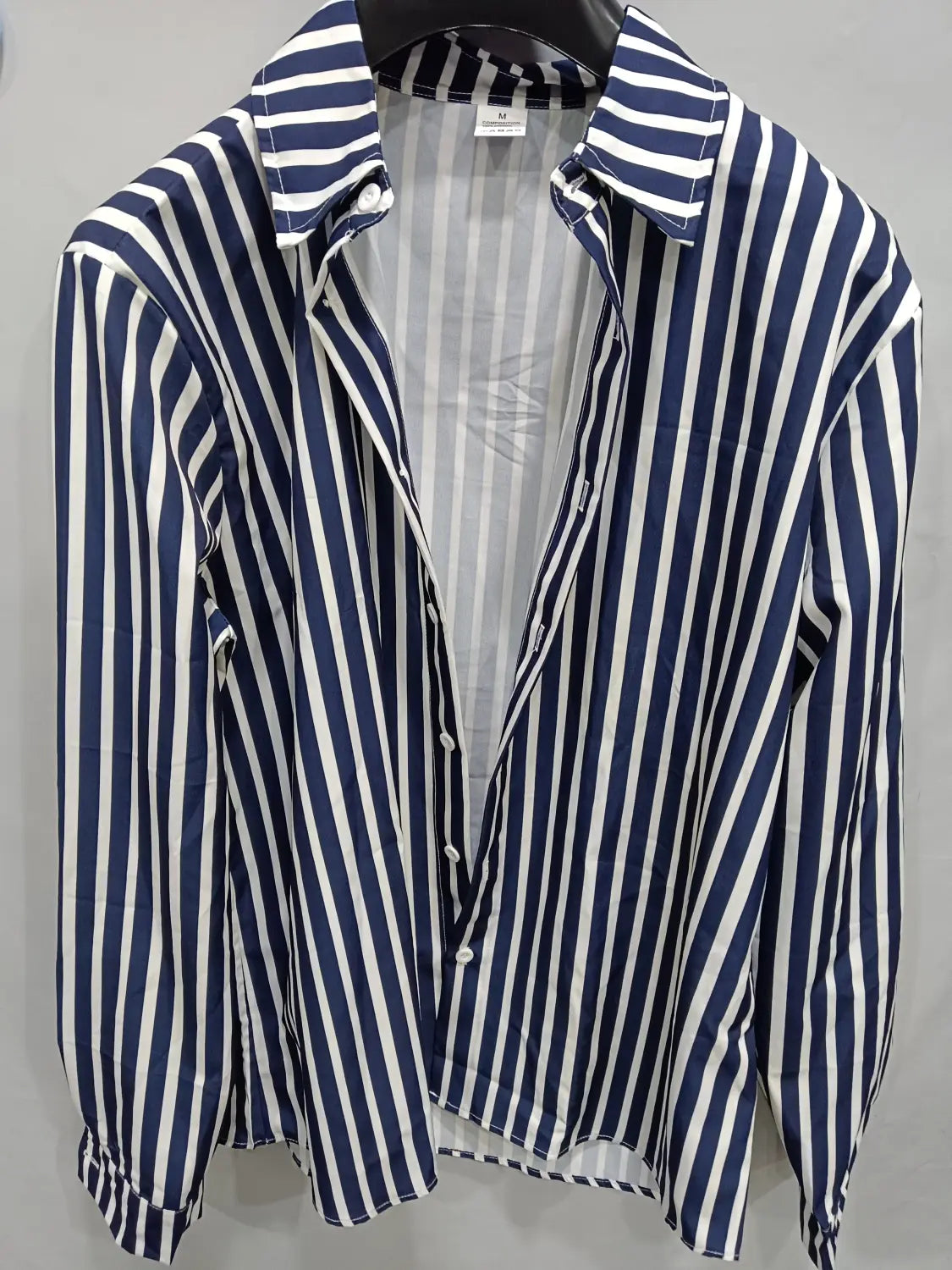 Chemise décontractée à manches longues rayée verticalement bleu marine et blanc pour hommes, avec col classique et patte boutonnée.