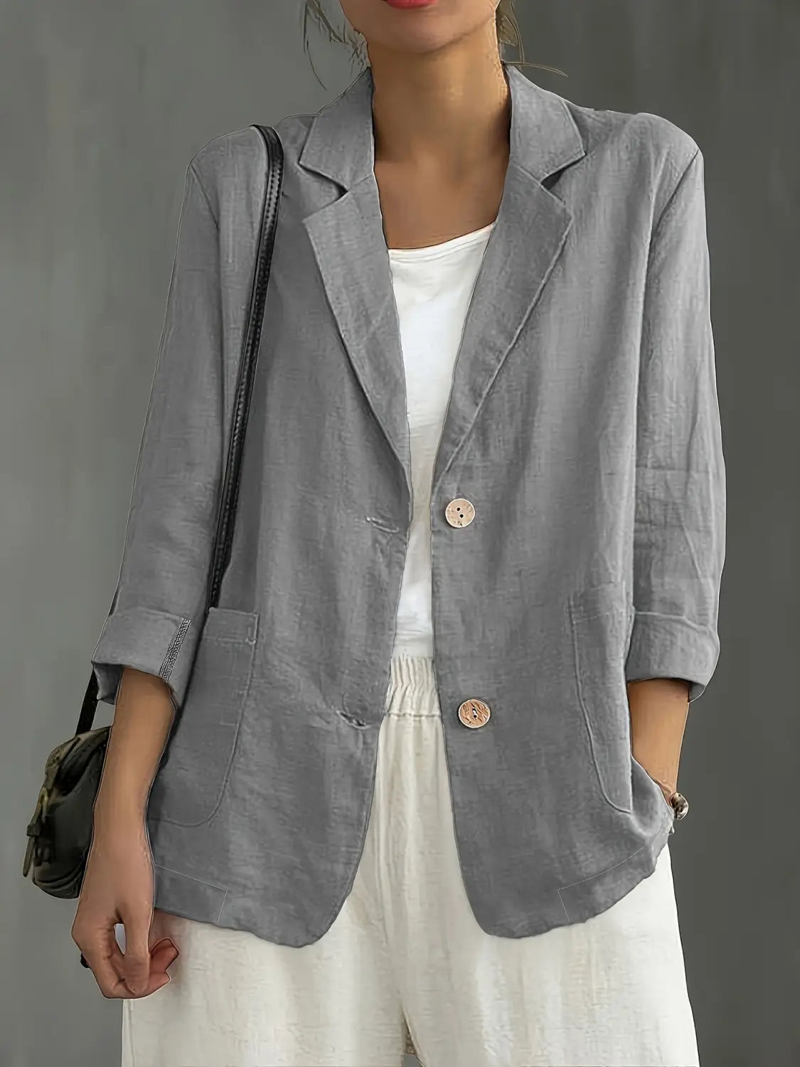 Blazer de lino gris con mangas remangadas y botones de madera, diseñado para ropa de trabajo casual para mujer.