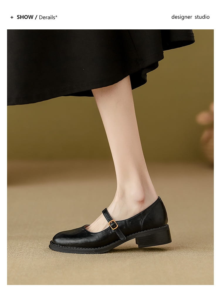 black leather mary jane shoe with a gold buckle and low block heel shown from the back side