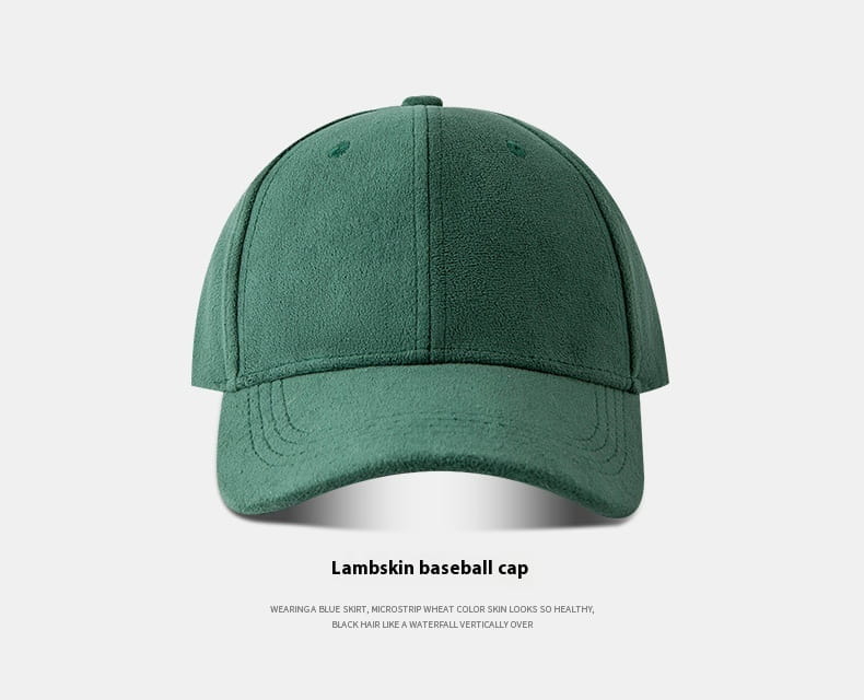 A dark green suede baseball cap with a soft minimalist design featuring lambskin material, a classic six-panel construction, and a stitched brim.