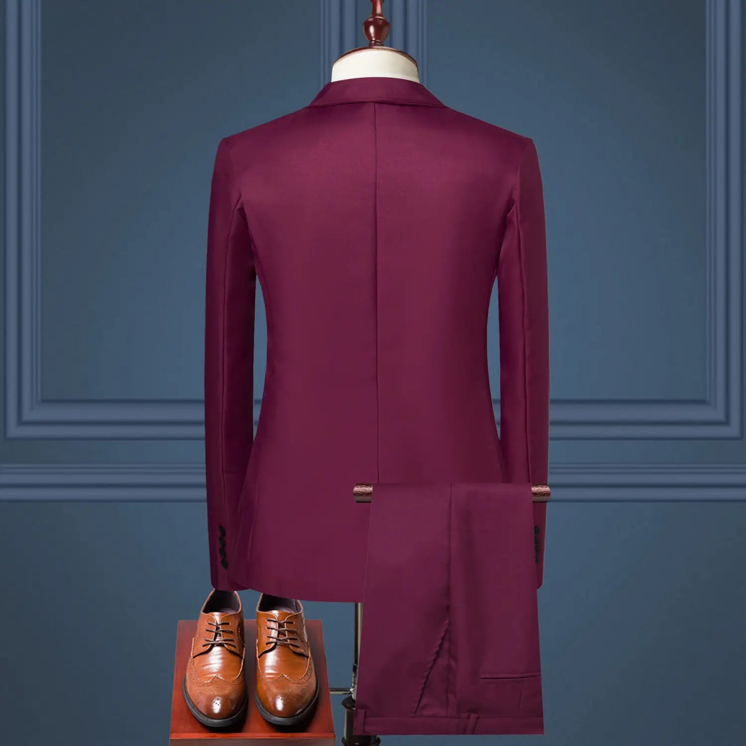 A tailored burgundy solid color two piece leisure suit featuring a modern cut jacket and matching trousers displayed on a mannequin.