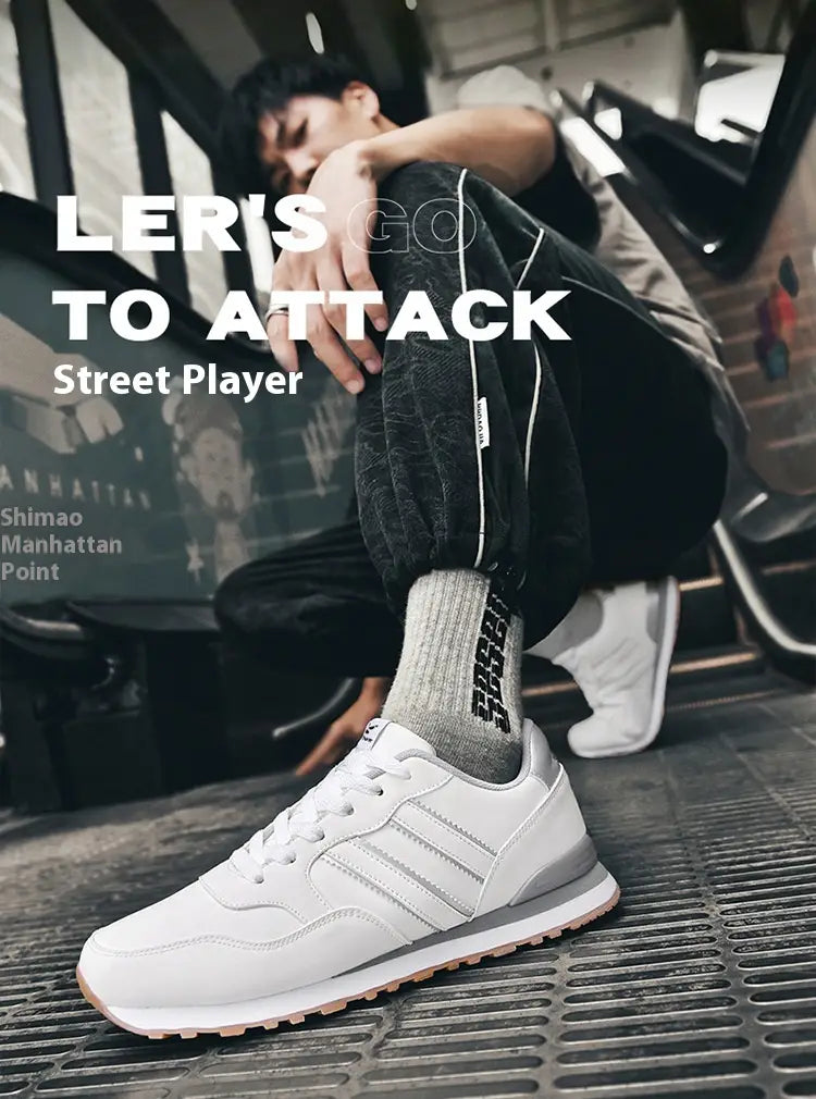 Chaussure de sport basse pour la course en cuir blanc, comportant trois bandes grises parallèles et une semelle en caoutchouc de couleur gomme, pour un usage décontracté rétro.