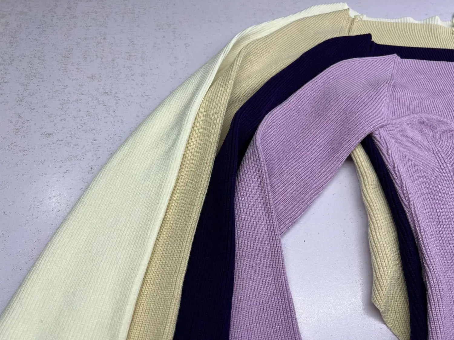 A ribbed sweetheart neck long sleeve knit pullover in soft lavender with a subtle sheen and slightly textured ribbed knit fabric.