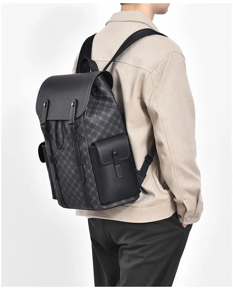 Men’s black leather business travel backpack with subtle monogram pattern and front flap closure featuring a laptop sleeve.