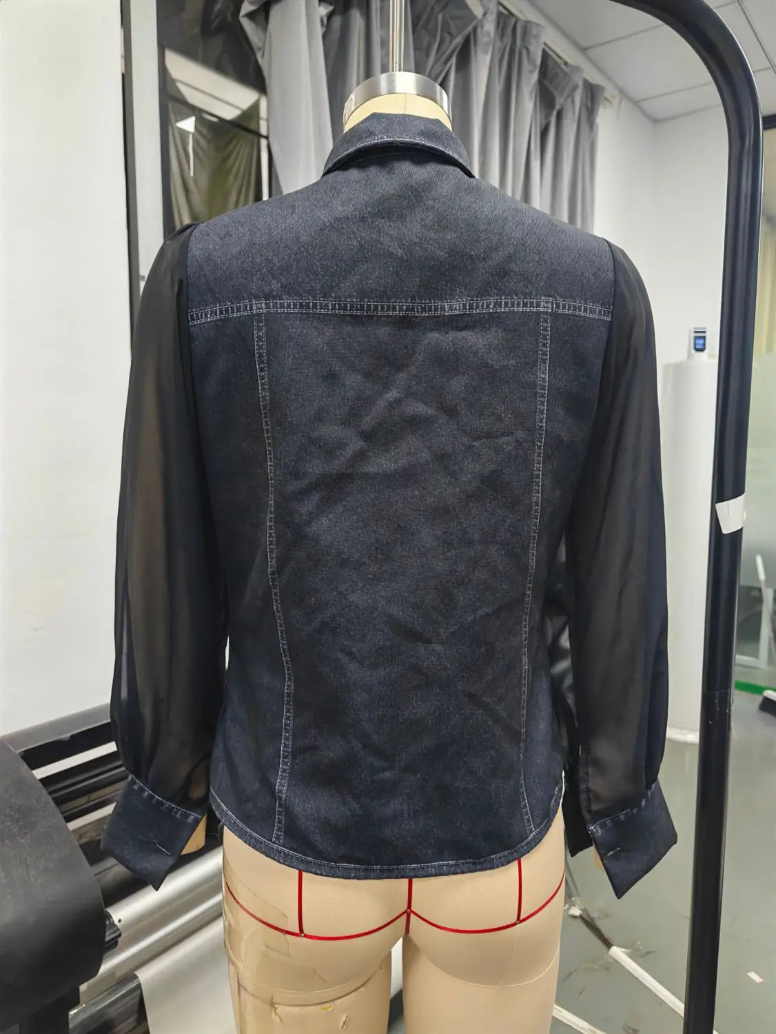 Veste en denim bleu foncé à manches transparentes, avec col classique et détails de surpiqûres visibles, faisant partie d’un ensemble pour haut à encolure en V à manches transparentes en denim