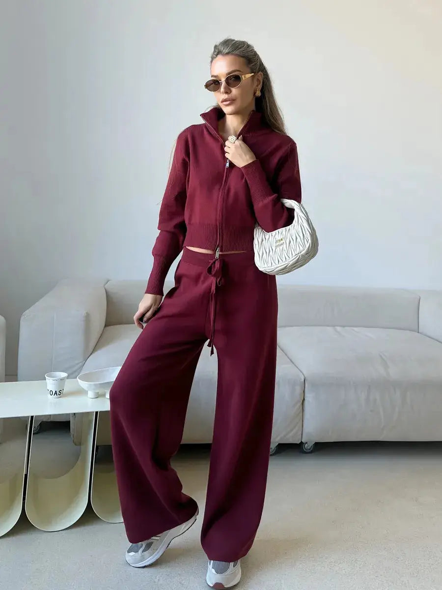 White quilted handbag with a distinctive zigzag pattern paired with a women’s knit zip up cardigan and wide leg pant set.
