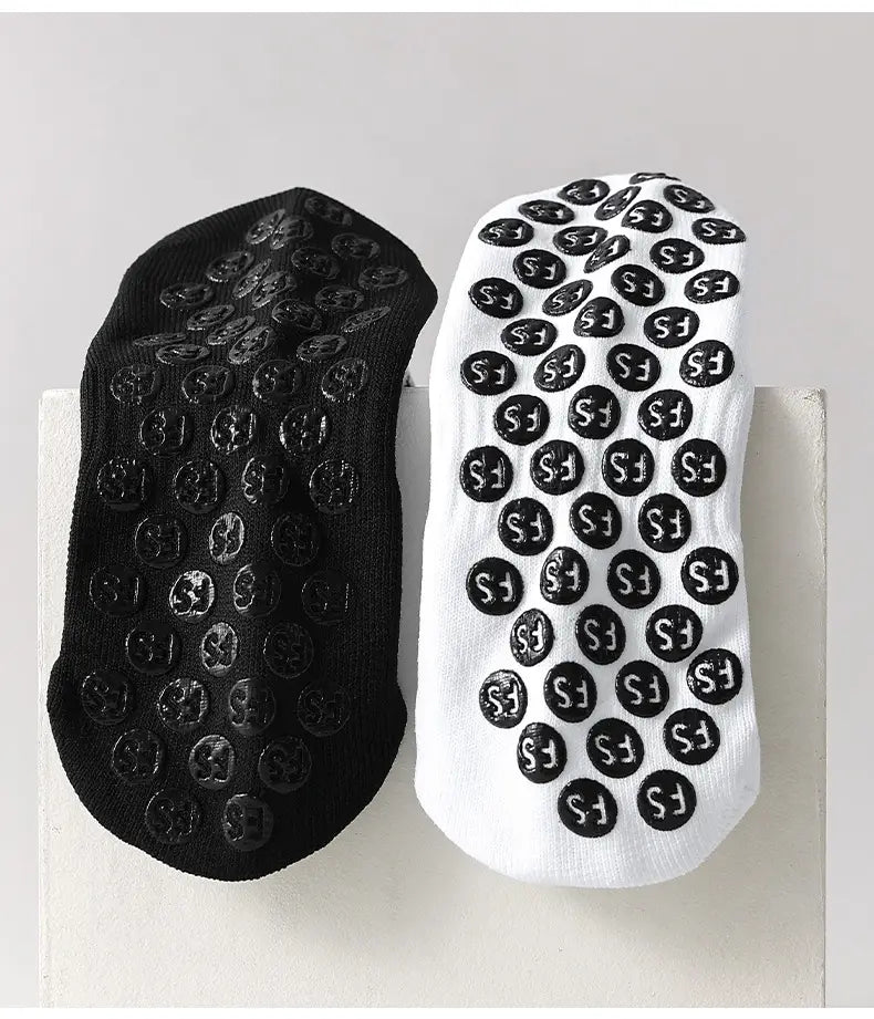 Black and white anti-slip football grip socks for men featuring textured circular rubber pads on the soles.