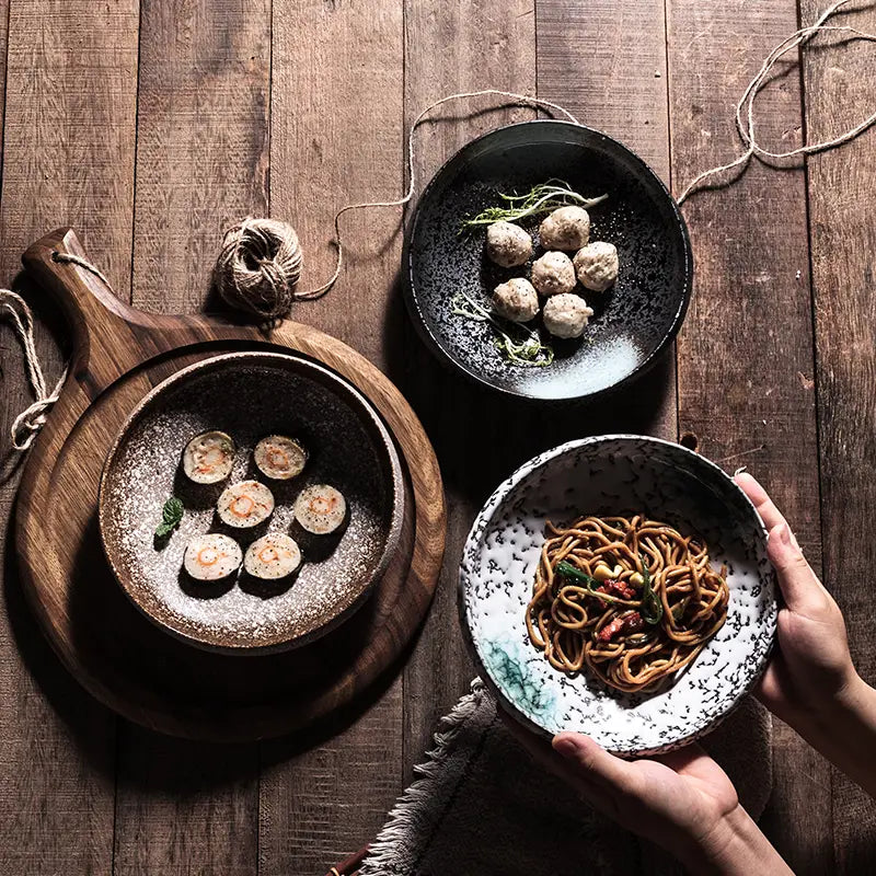 Black speckled ceramic serving bowl holding noodles with vegetables and meat for home kitchens.