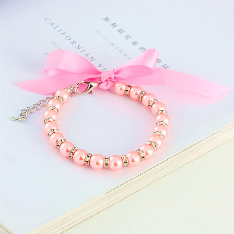 collier délicat de perles pour animal à ruban pastel couleur rose, avec accents en métal à finition dorée, de petites pierres serties de strass et un ruban en satin rose pâle.