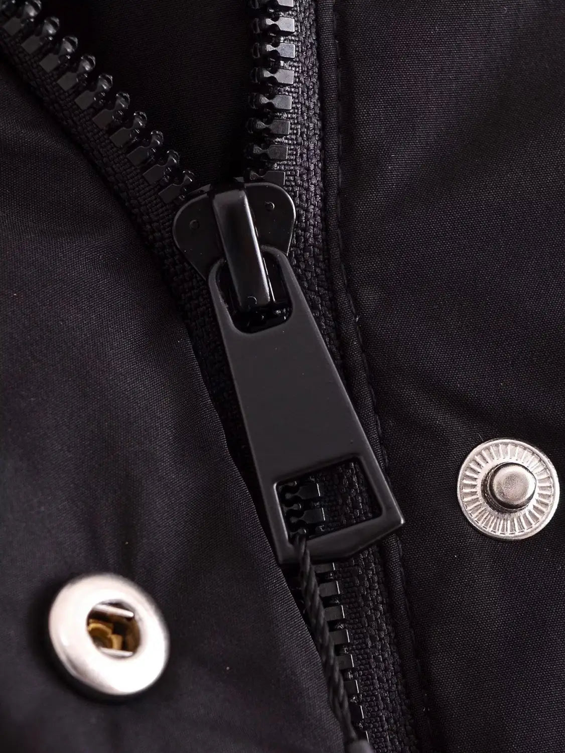 Black quilted hooded puffer coat featuring a black zipper pull with a matte finish and textured grip against dark fabric.