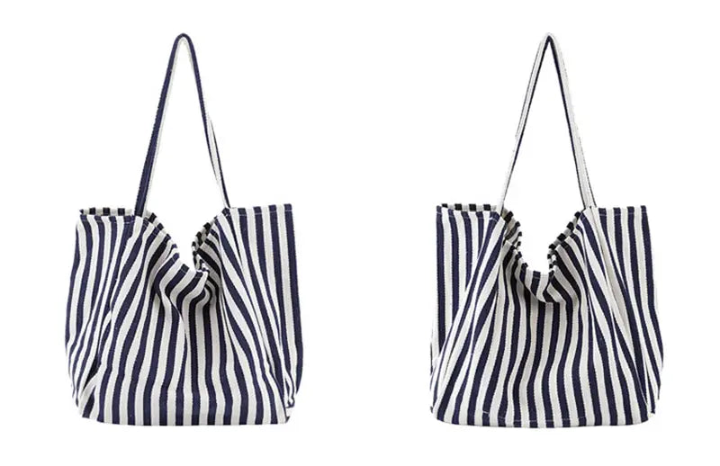Navy and white vertically striped canvas tote bag with matching handles designed as a high capacity shoulder bag.