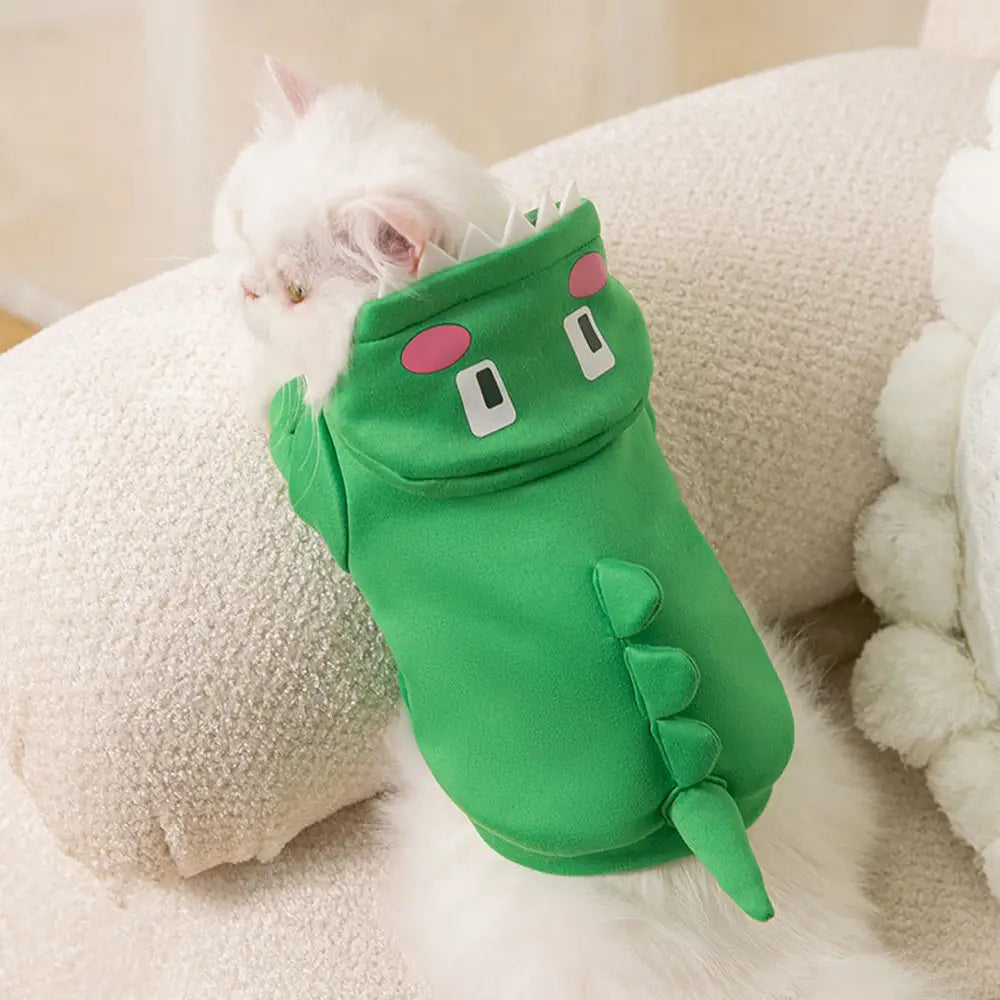 Green dinosaur-themed plush pet hoodie with pink cheeks and white eyes designed as a dinosaur cat hoodie plush pet costume.
