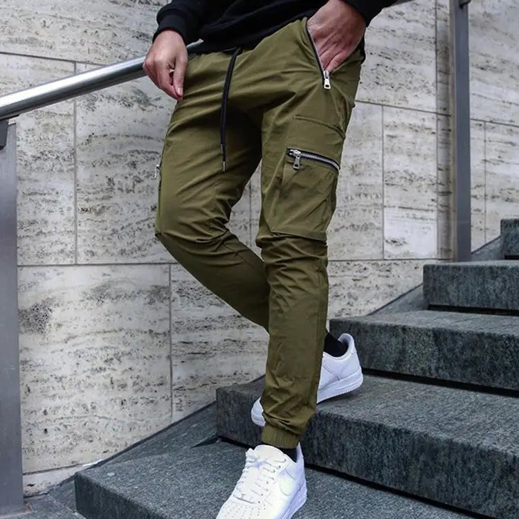 Men’s olive green zipper cargo joggers casual pants feature multiple zippered pockets and a drawstring waistband for a comfortable fit.