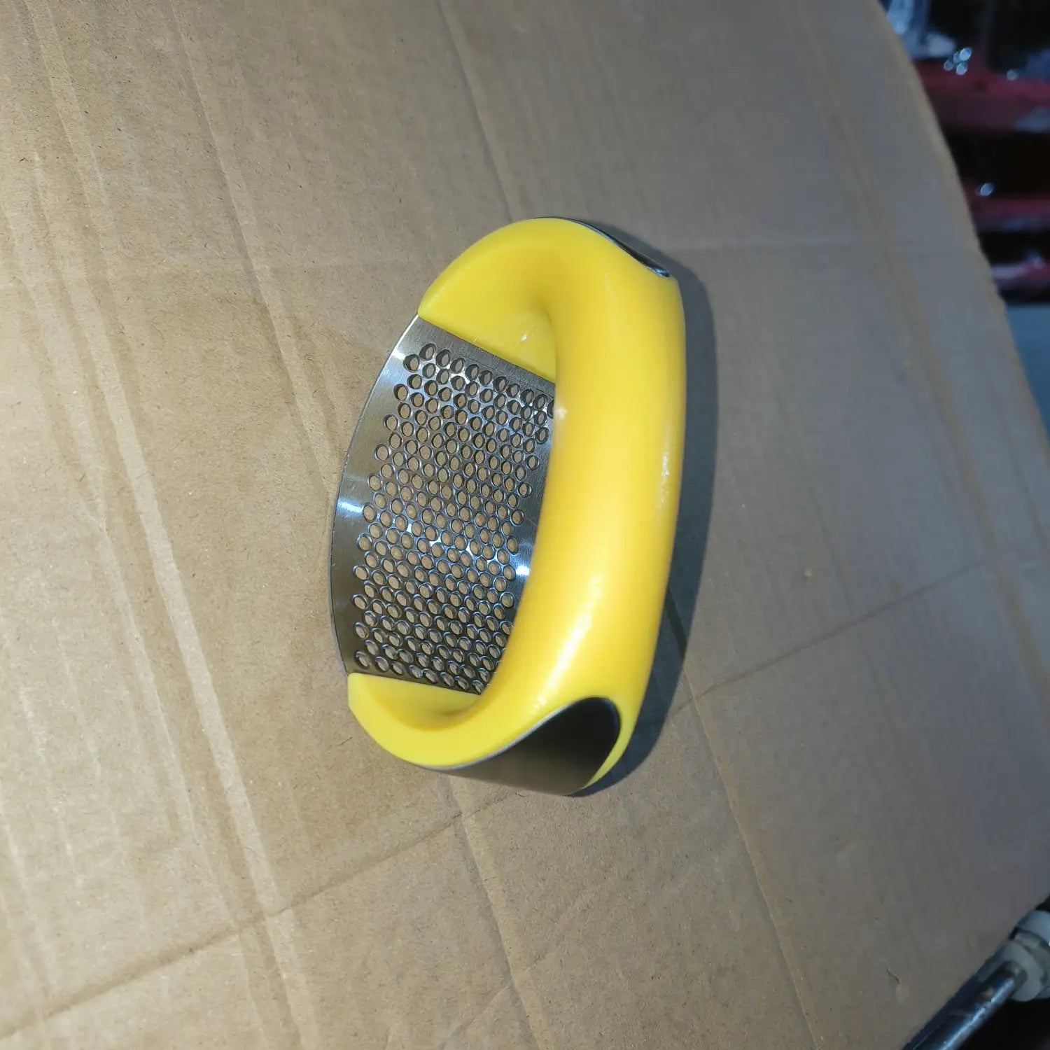 Presse-ail à poignée jaune, outil de hachage manuel ergonomique avec surface de râpage en acier inoxydable pour un hachage manuel.